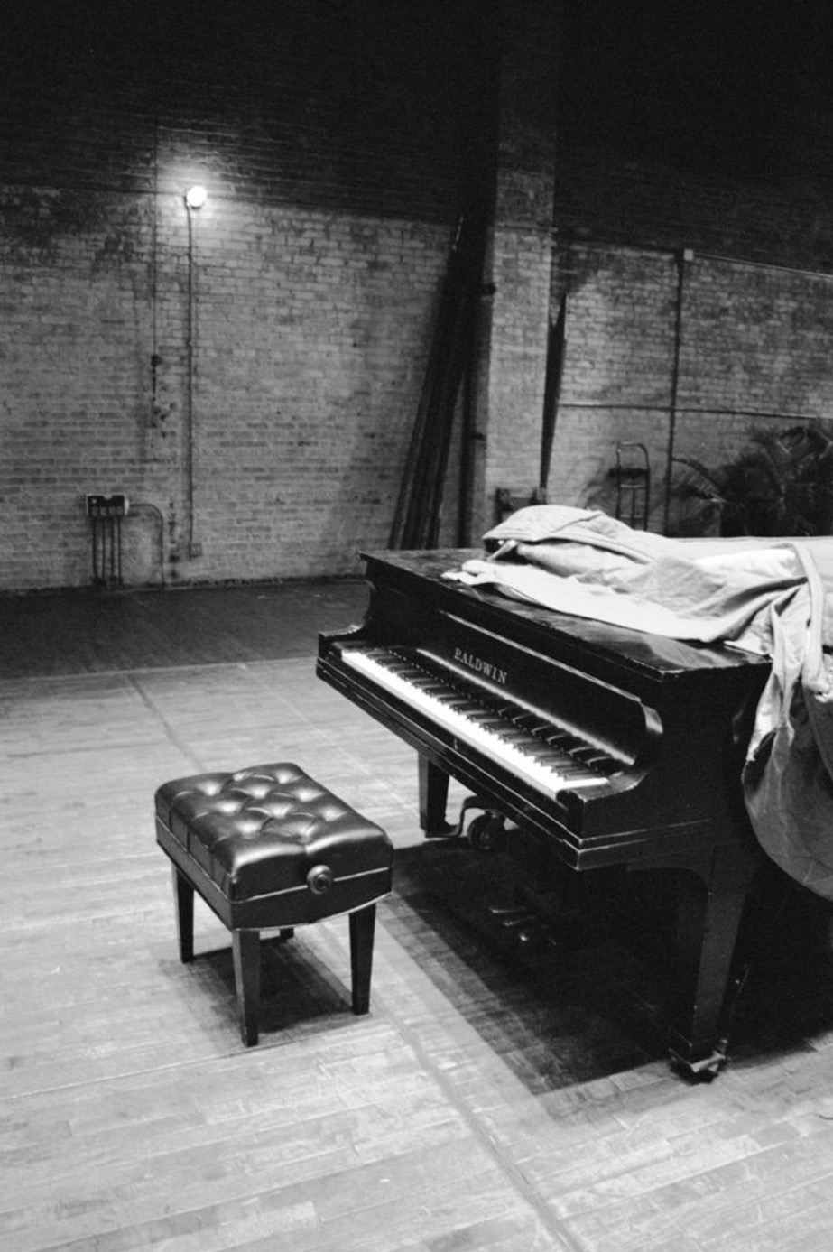 A grand piano waiting on a performance stage